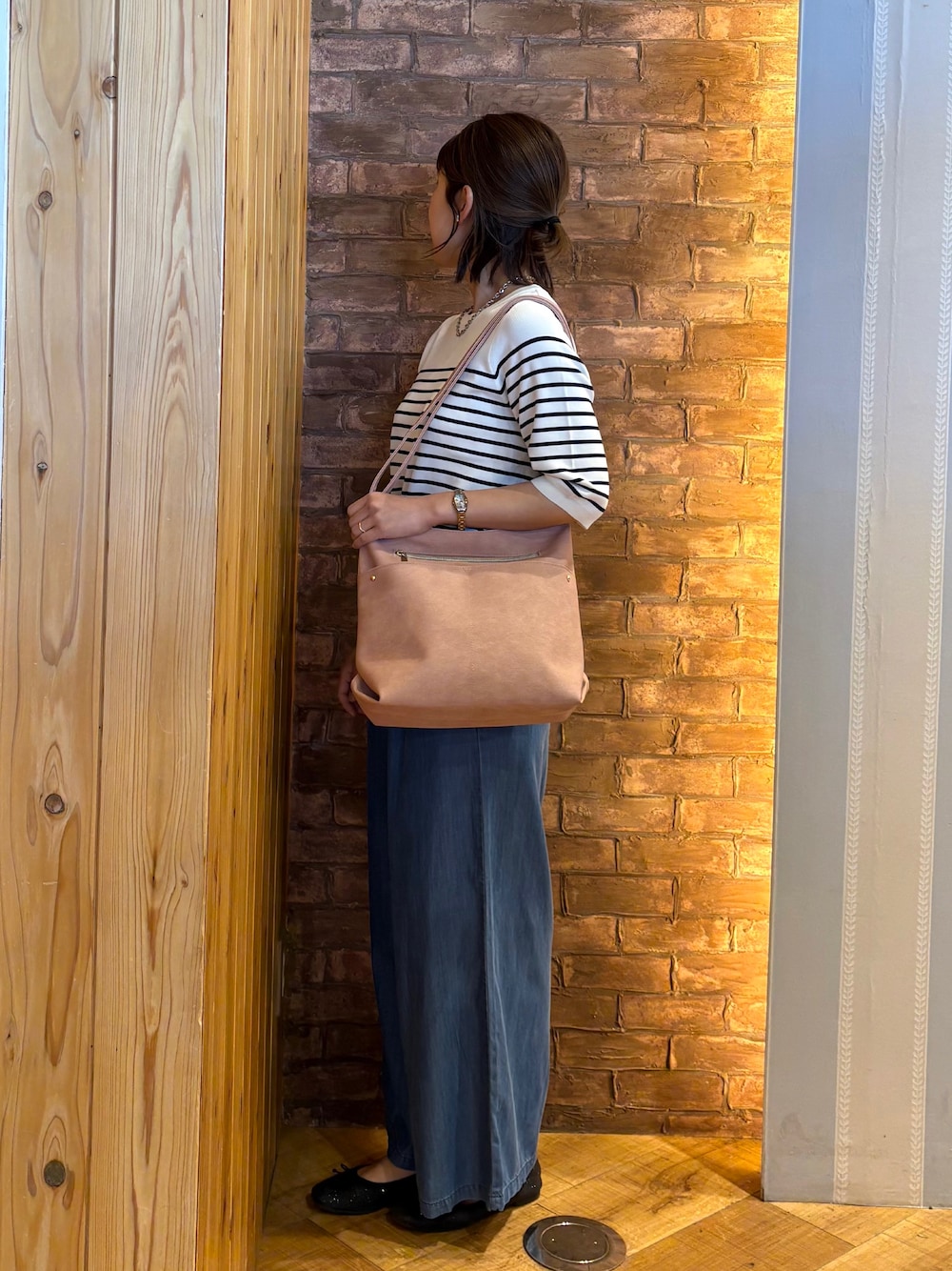 ベージュ系のショルダーバッグ、ホワイト系のニット/セーター、ブルー系のその他パンツを着用したレディースの夏コーディネートの2枚目の写真