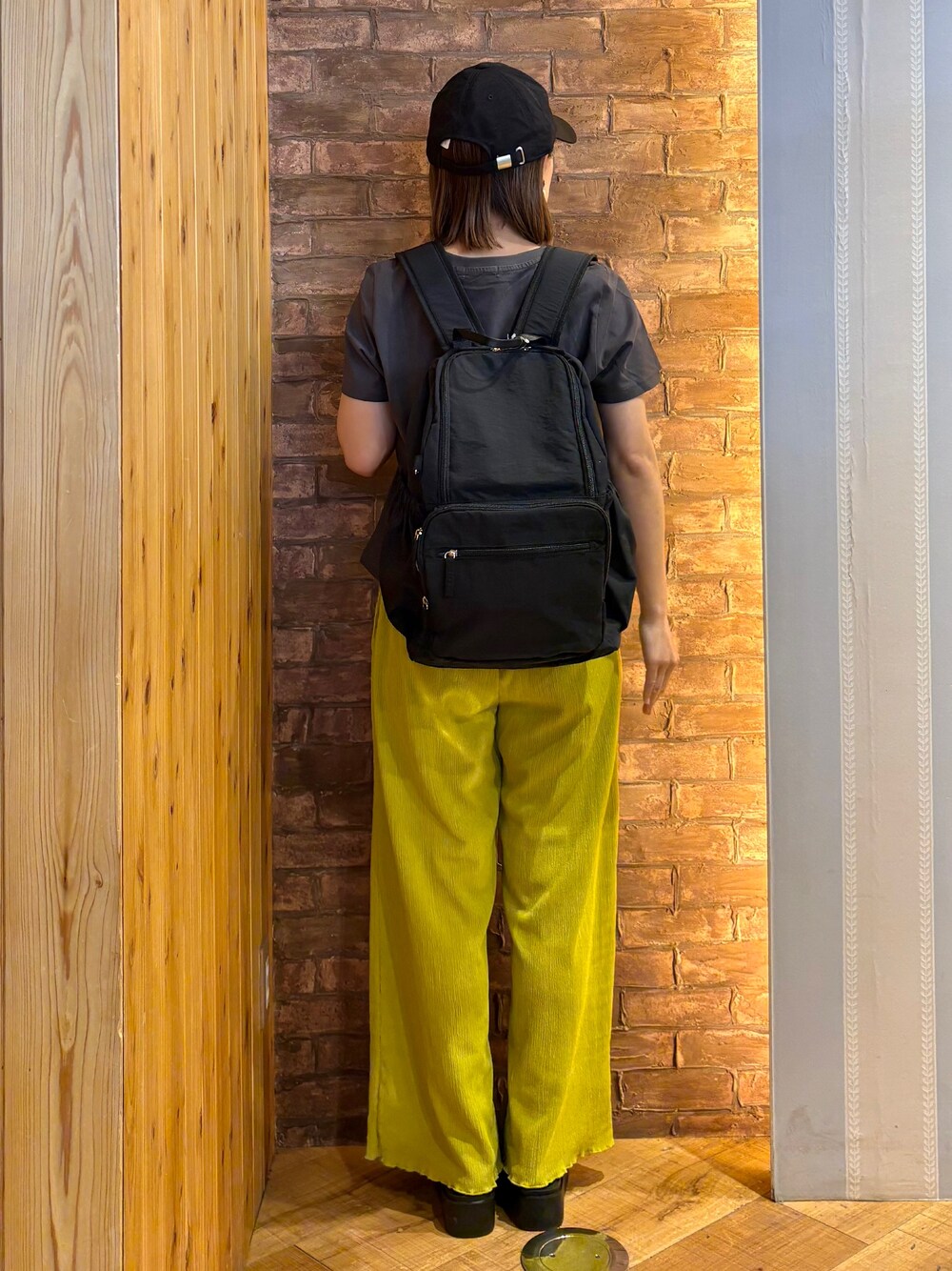グレー系のTシャツ/カットソー、イエロー系のその他パンツ、ブラック系のサンダルを着用したレディースの春コーディネートの3枚目の写真