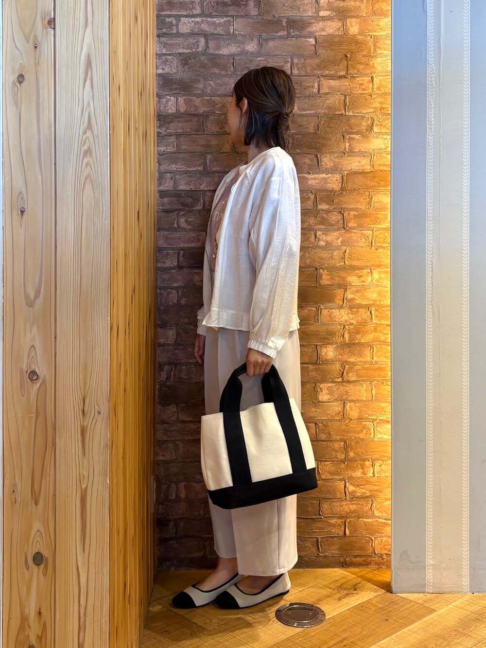 ブラック系のトートバッグ、ベージュ系のパンプス、ベージュ系のその他パンツを着用したレディースの春コーディネートの2枚目の写真