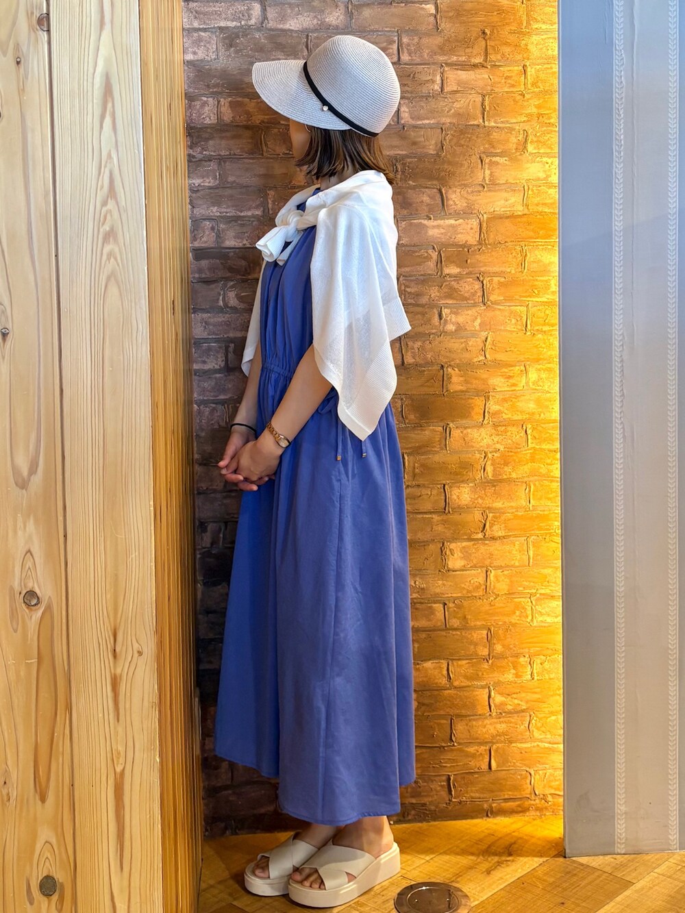 ホワイト系のカーディガン/ボレロ、ブルー系のワンピース、ベージュ系のサンダルを着用したレディースの夏コーディネートの2枚目の写真