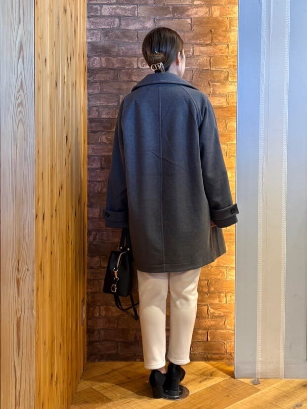 グレー系のチェスターコート、ブルー系のニット/セーター、ホワイト系のその他パンツを着用したレディースの冬コーディネートの3枚目の写真