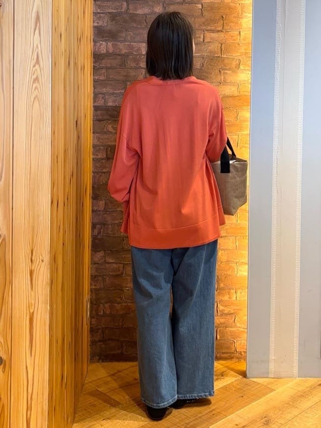 オレンジ系のカーディガン/ボレロ、ホワイト系のタンクトップ、ブルー系のデニムパンツを着用したレディースの春コーディネートの3枚目の写真