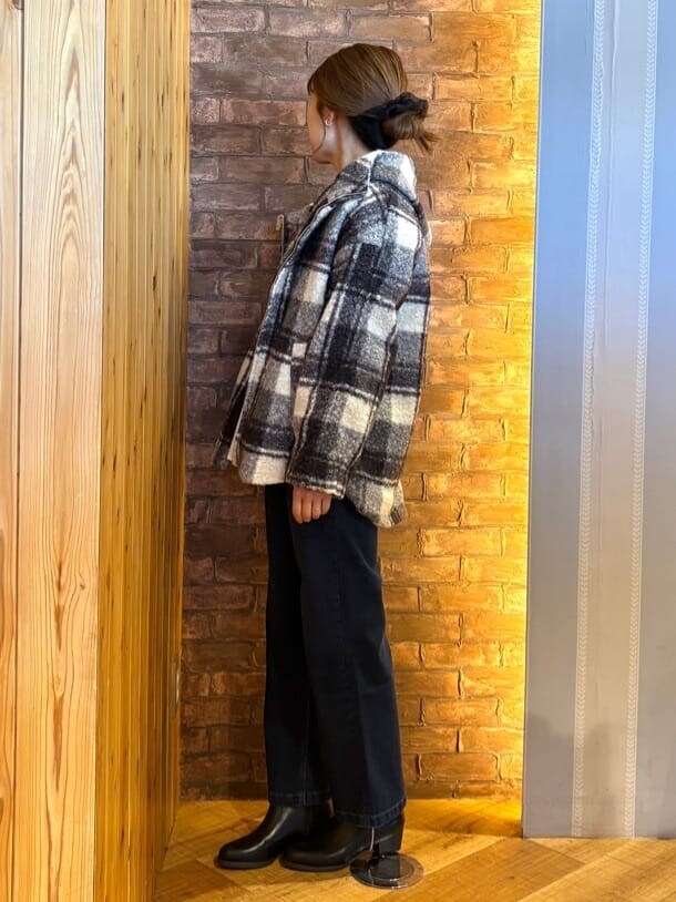 ブラック系のその他アウター、オレンジ系のTシャツ/カットソー、ブルー系のデニムパンツを着用したレディースの秋コーディネートの2枚目の写真
