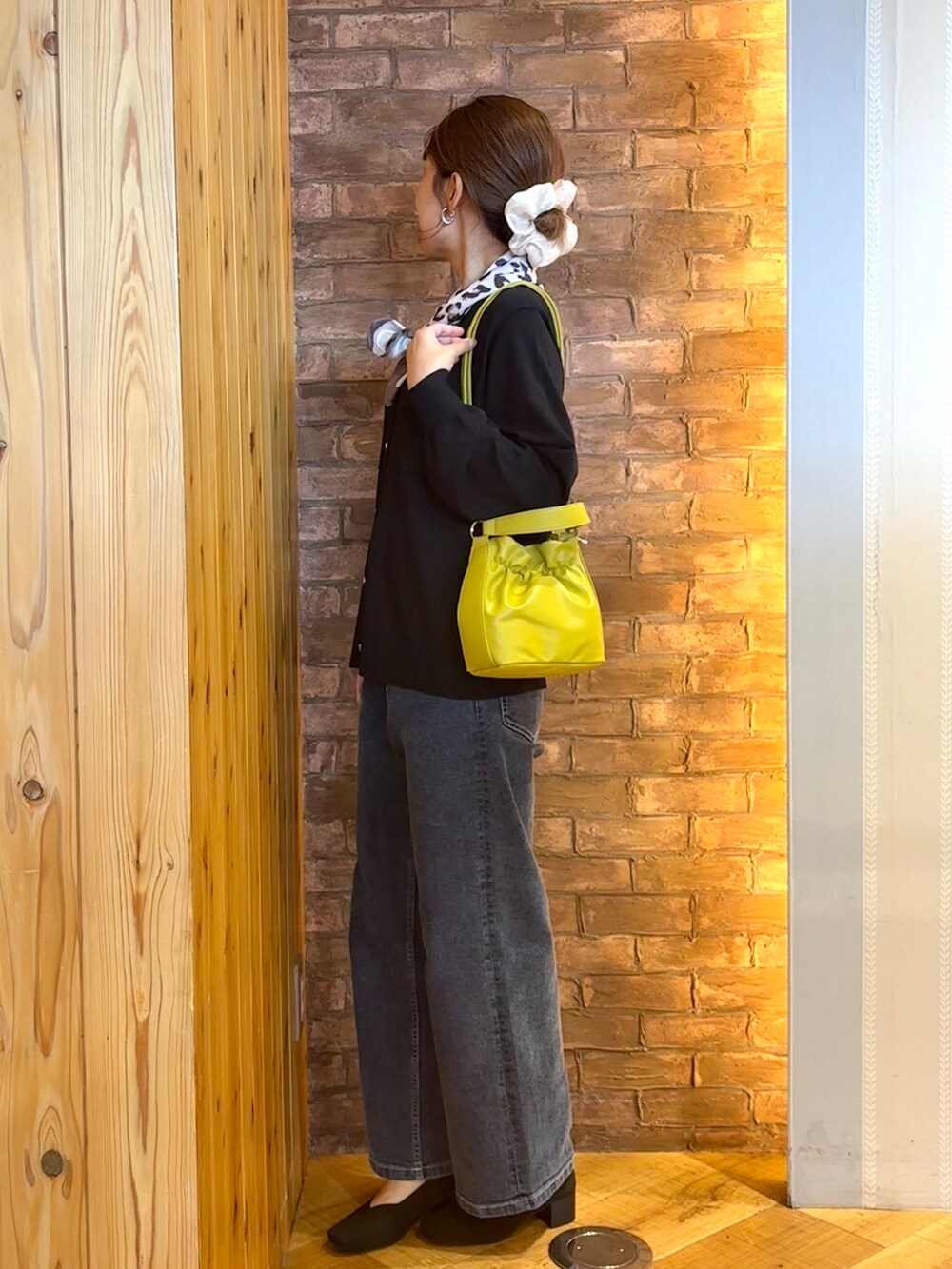ブラック系のカーディガン/ボレロ、ブルー系のデニムパンツ、ブラック系のパンプスを着用したレディースの秋コーディネートの2枚目の写真