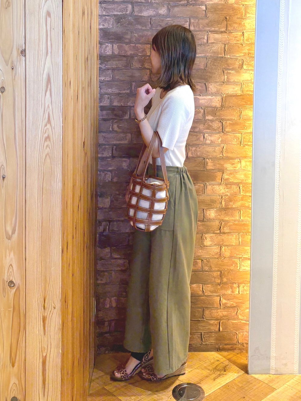 ホワイト系のニット/セーター、グリーン系のその他パンツ、ブラウン系のサンダルを着用したレディースの夏コーディネートの2枚目の写真