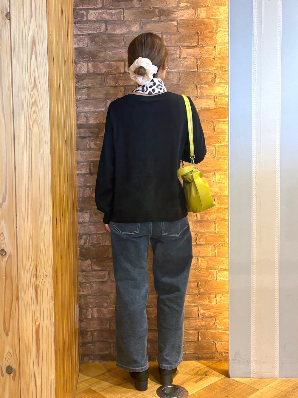 ブラック系のカーディガン/ボレロ、ブルー系のデニムパンツ、ブラック系のパンプスを着用したレディースの秋コーディネートの3枚目の写真