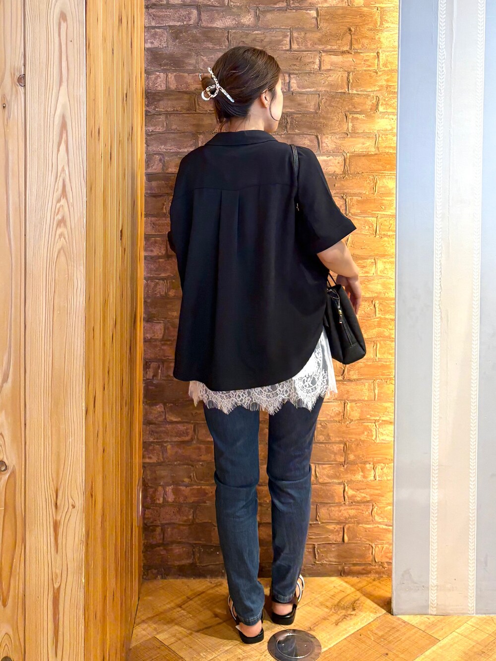 ブラック系のシャツ/ブラウス、ホワイト系のタンクトップ、ブルー系のデニムパンツを着用したレディースの夏コーディネートの2枚目の写真
