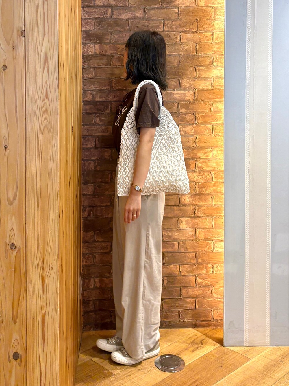 ブラウン系のTシャツ/カットソー、ベージュ系のその他パンツ、ホワイト系のトートバッグを着用したレディースの夏コーディネートの2枚目の写真