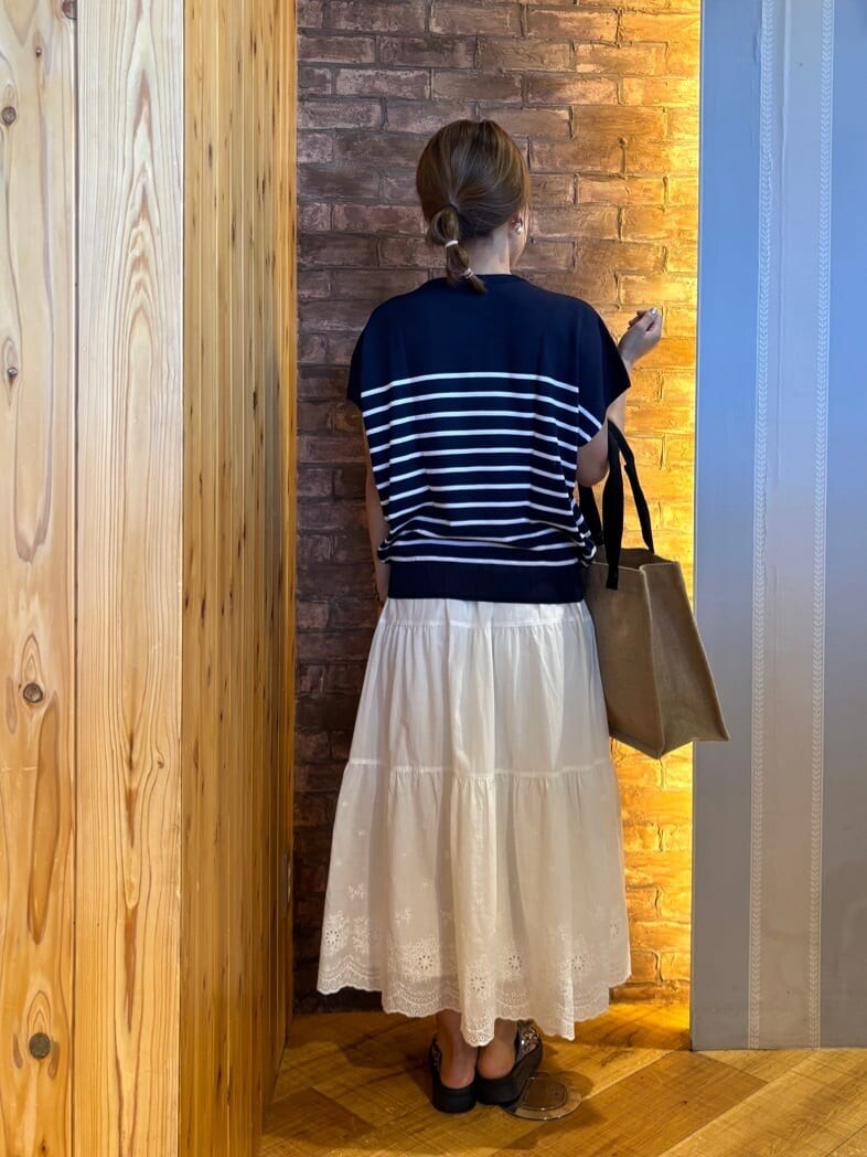 ブルー系のニット/セーター、ホワイト系のスカート、シルバー系のサンダルを着用したレディースの夏コーディネートの3枚目の写真