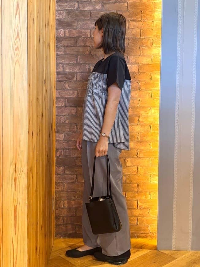 ブラック系のTシャツ/カットソー、グレー系のその他パンツ、ブラック系のパンプスを着用したレディースの春コーディネートの2枚目の写真