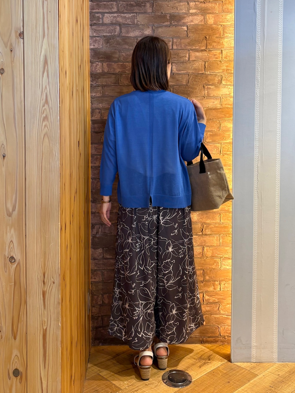 ブルー系のカーディガン/ボレロ、ブラック系のトートバッグ、ホワイト系のTシャツ/カットソーを着用したレディースの春コーディネートの3枚目の写真