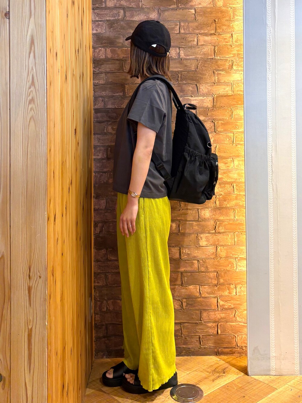 グレー系のTシャツ/カットソー、イエロー系のその他パンツ、ブラック系のサンダルを着用したレディースの春コーディネートの2枚目の写真