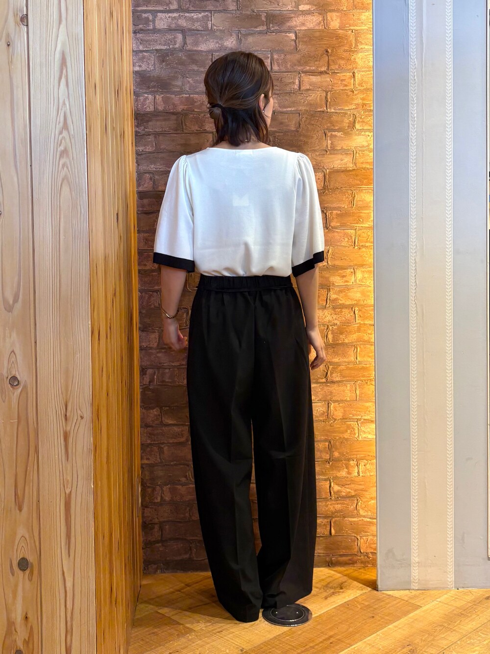 ブラック系のその他パンツ、ホワイト系のニット/セーター、ベージュ系のパンプスを着用したレディースの夏コーディネートの3枚目の写真