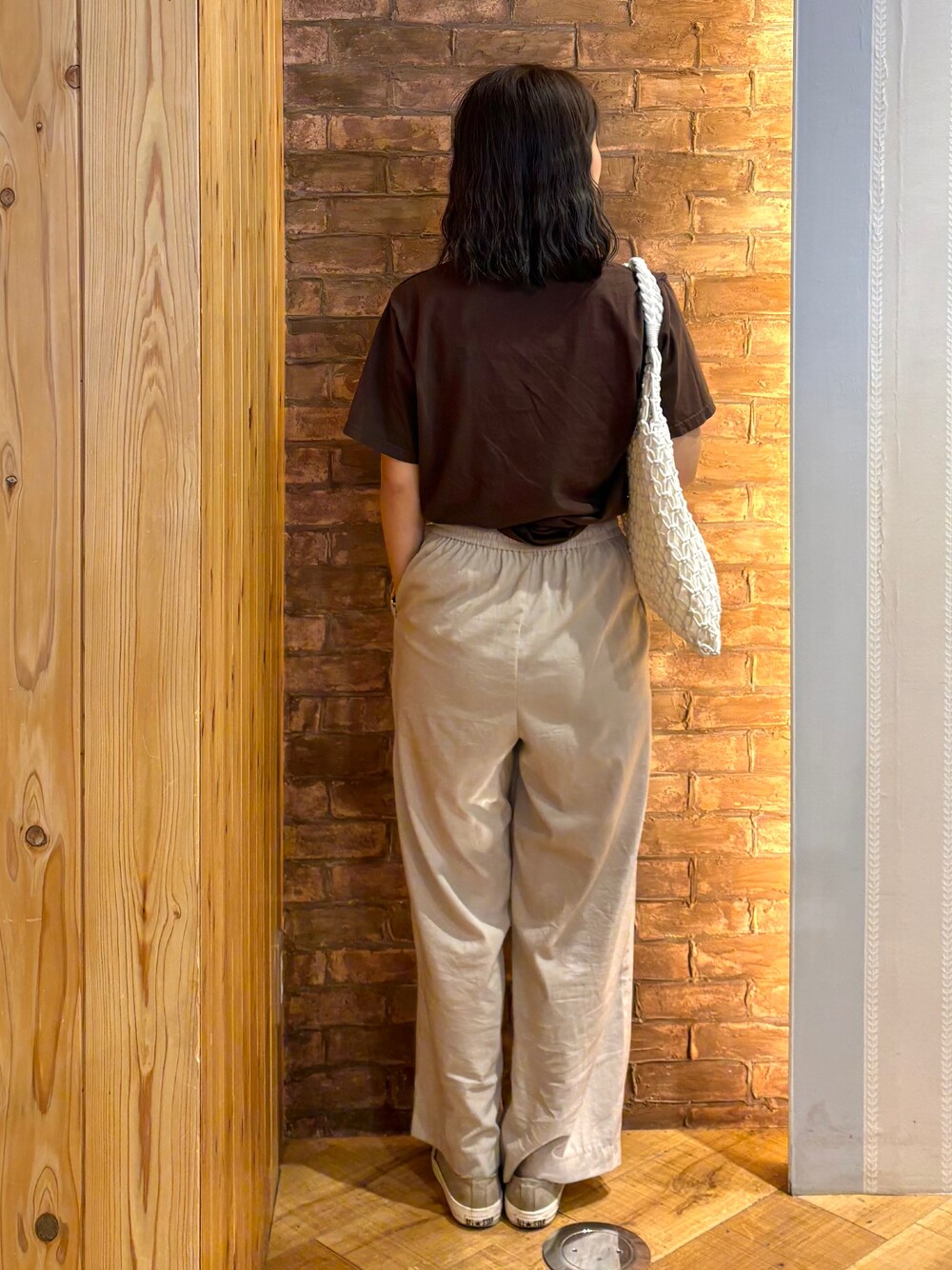 ブラウン系のTシャツ/カットソー、ベージュ系のその他パンツ、ホワイト系のトートバッグを着用したレディースの夏コーディネートの3枚目の写真