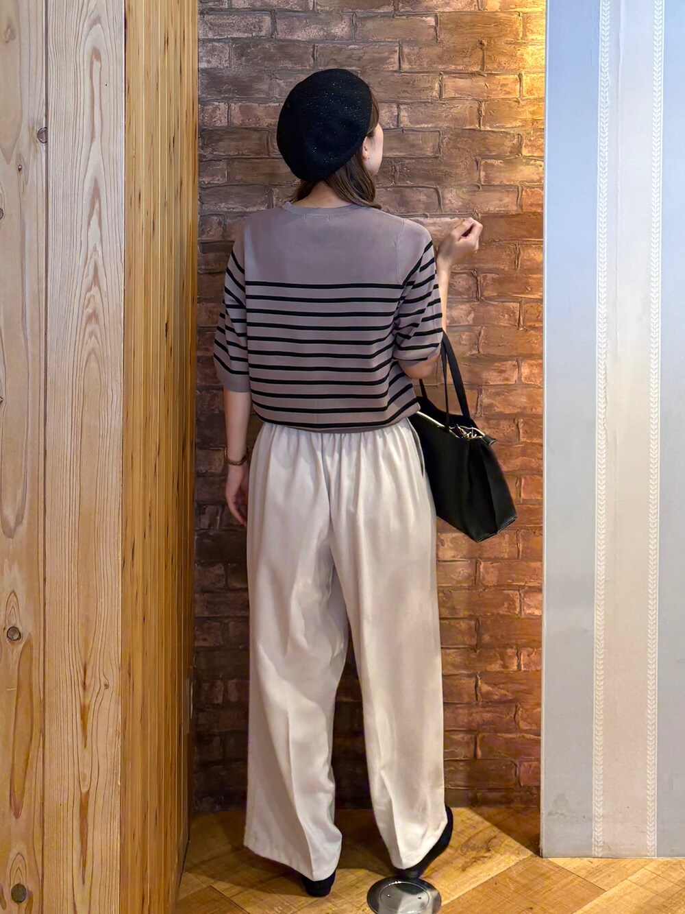 ブラウン系のニット/セーター、ベージュ系のその他パンツ、ブラック系のその他シューズを着用したレディースの夏コーディネートの3枚目の写真