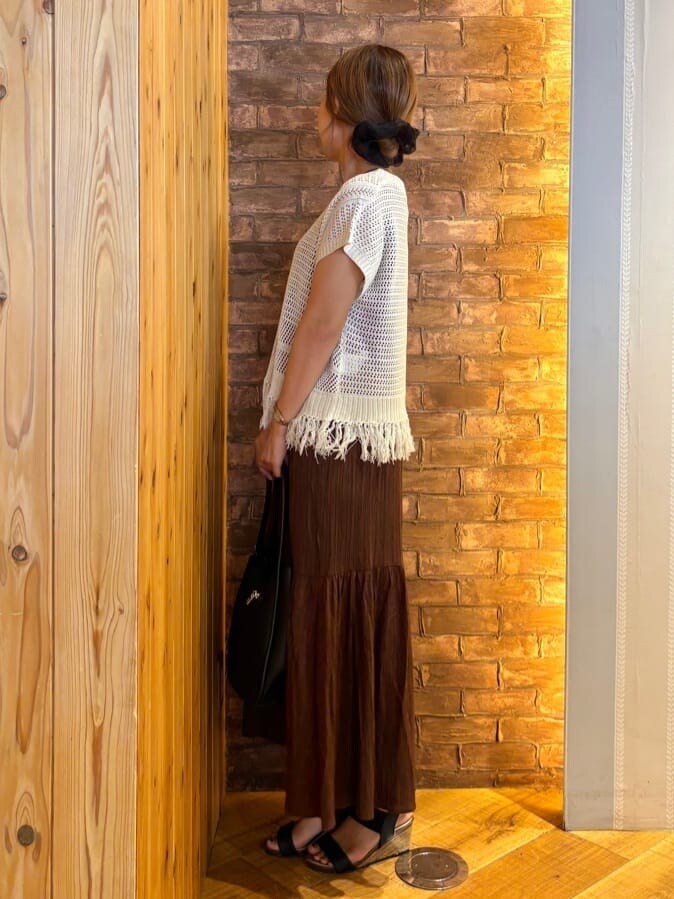 ホワイト系のニット/セーター、ブラウン系のワンピース、ブラック系のサンダルを着用したレディースの夏コーディネートの2枚目の写真