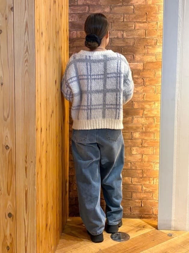 ホワイト系のニット/セーター、ブルー系のデニムパンツ、ブラック系のブーツを着用したレディースの冬コーディネートの3枚目の写真