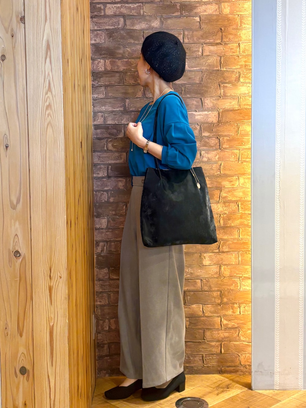 ブルー系のTシャツ/カットソー、ベージュ系のその他パンツ、ブラック系のパンプスを着用したレディースの秋コーディネートの2枚目の写真