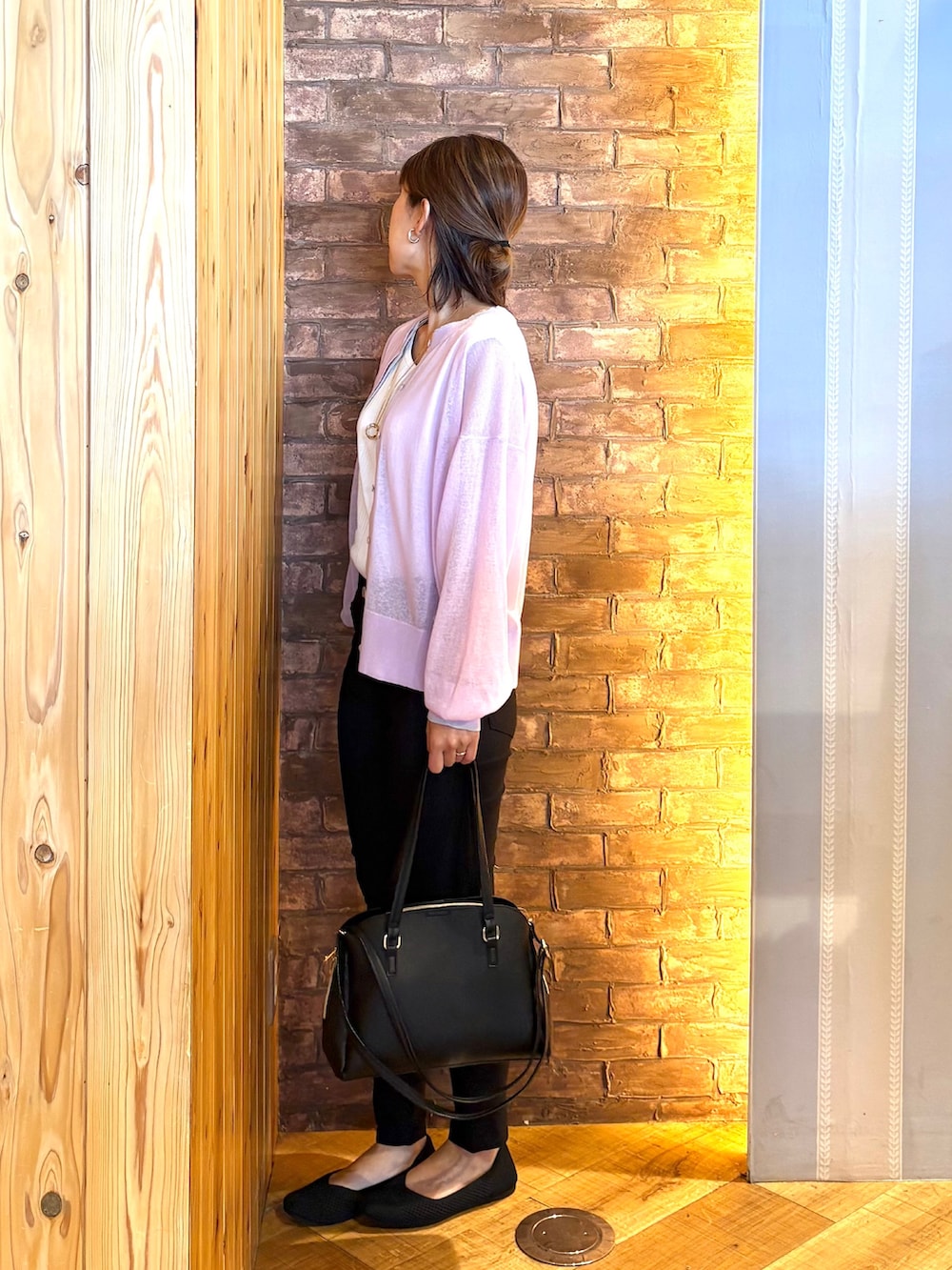 ブラック系のトートバッグ、ブラック系のパンプス、ホワイト系のタンクトップを着用したレディースの春コーディネートの2枚目の写真