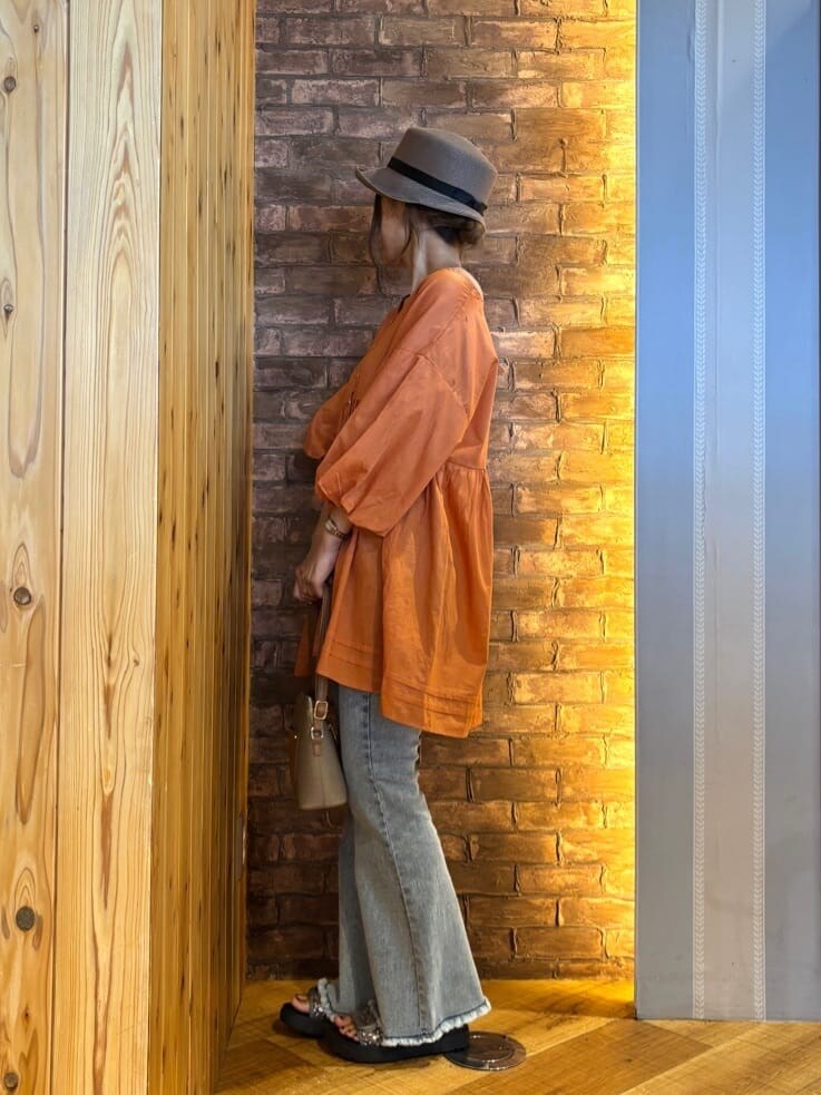 オレンジ系のシャツ/ブラウス、ブルー系のデニムパンツ、シルバー系のサンダルを着用したレディースの夏コーディネートの2枚目の写真