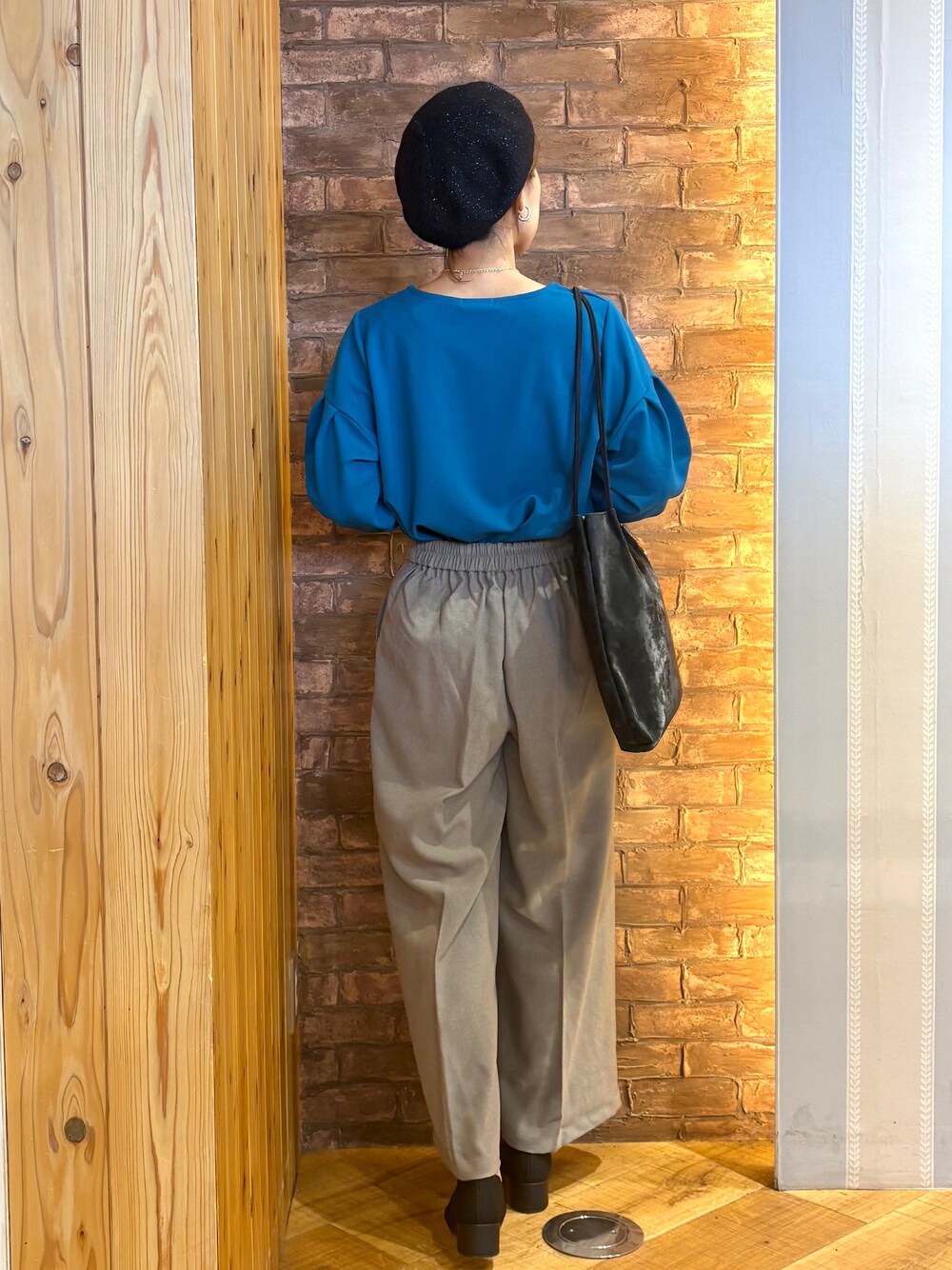 ブルー系のTシャツ/カットソー、ベージュ系のその他パンツ、ブラック系のパンプスを着用したレディースの秋コーディネートの3枚目の写真