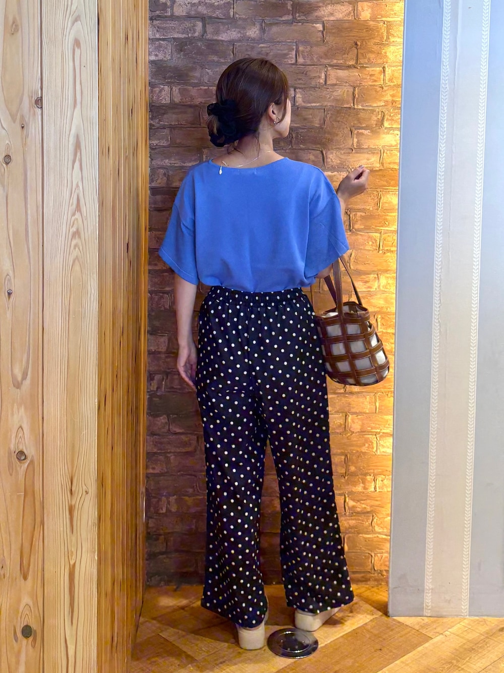 ブルー系のニット/セーター、ブラック系のその他パンツ、ベージュ系のサンダルを着用したレディースの夏コーディネートの3枚目の写真