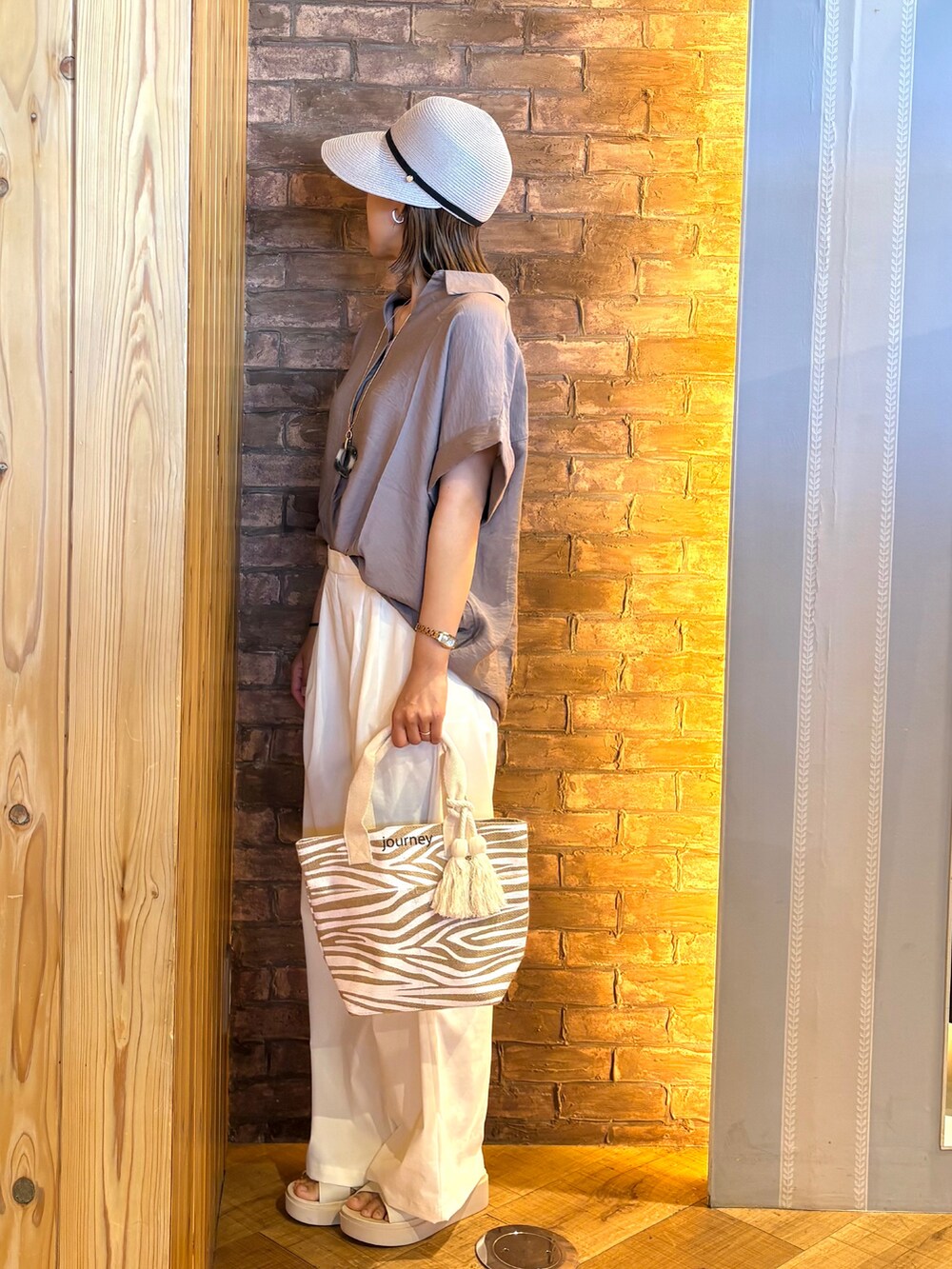 ベージュ系のトートバッグ、ホワイト系のその他パンツ、ブラウン系のシャツ/ブラウスを着用したレディースの春コーディネートの2枚目の写真