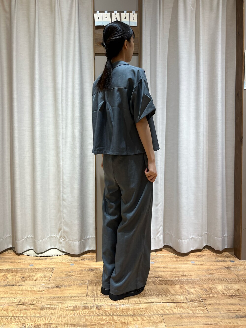 グレー系のパンツ、グレー系のシャツ/ブラウス、ブラック系のローファーを着用したレディースの夏コーディネートの2枚目の写真