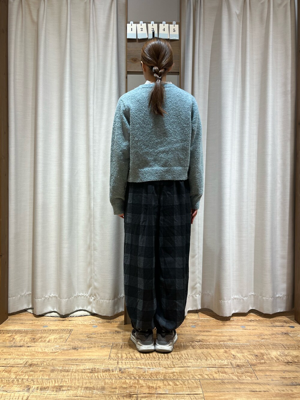 ブルー系のカーディガン/ボレロ、ブラック系のパンツを着用したレディースの冬コーディネートの2枚目の写真