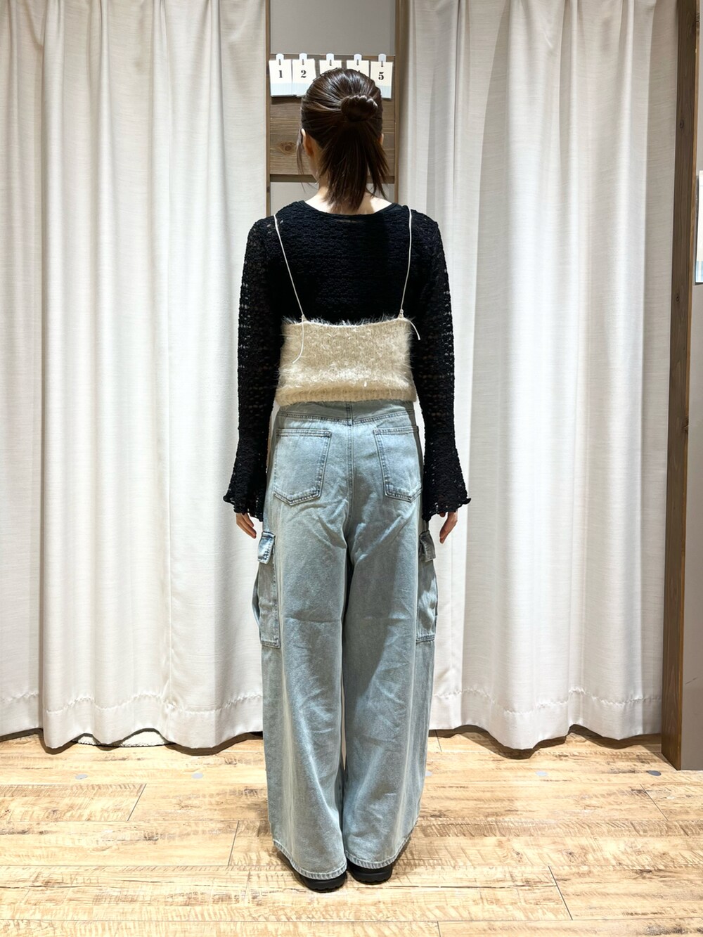 ブラック系のTシャツ/カットソー、ホワイト系のトップス、ブルー系のデニムパンツを着用したレディースの秋コーディネートの2枚目の写真