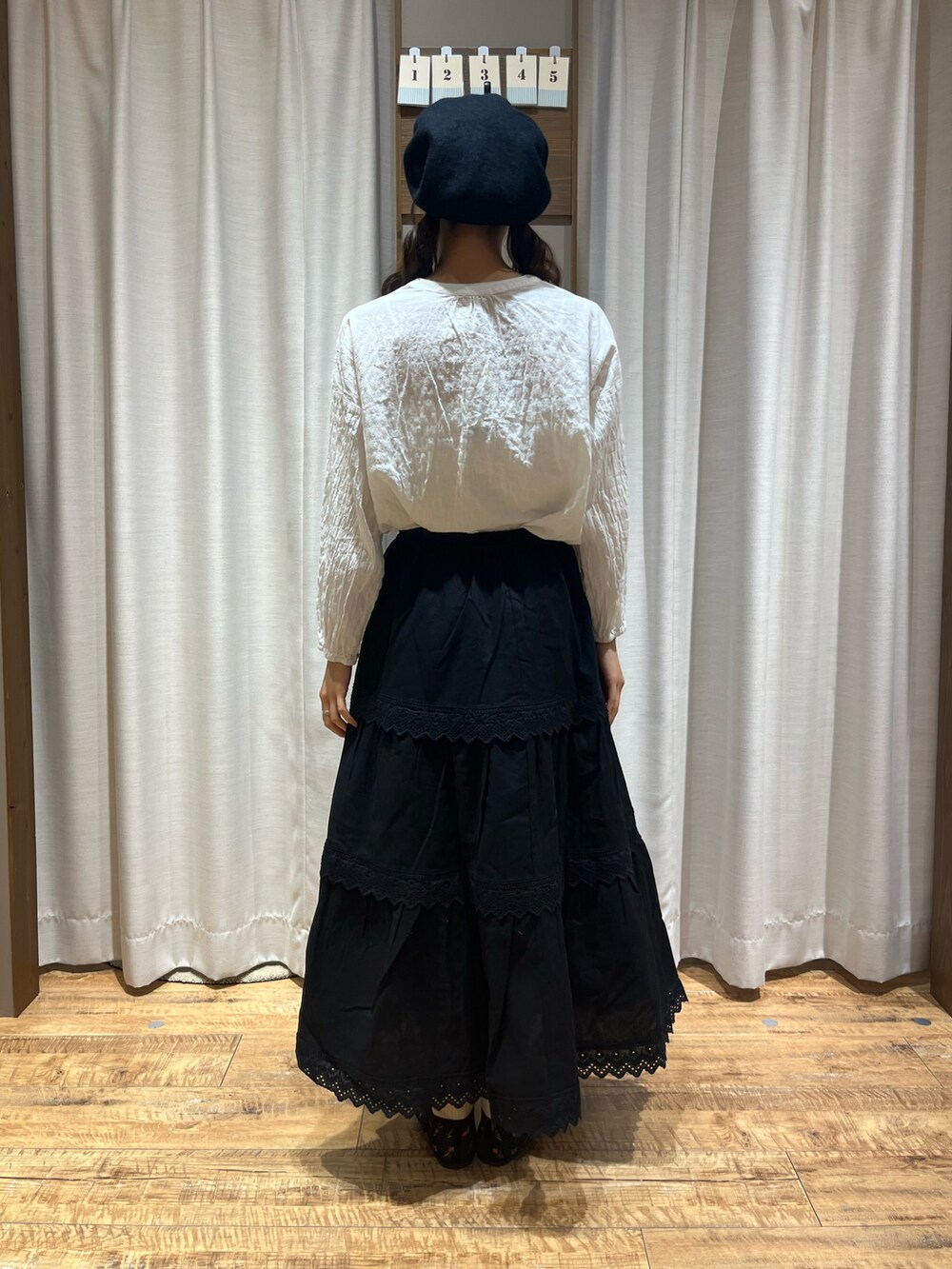 ブラック系のスカート、ブラック系のドレスシューズ、ホワイト系のシャツ/ブラウスを着用したレディースの秋コーディネートの3枚目の写真