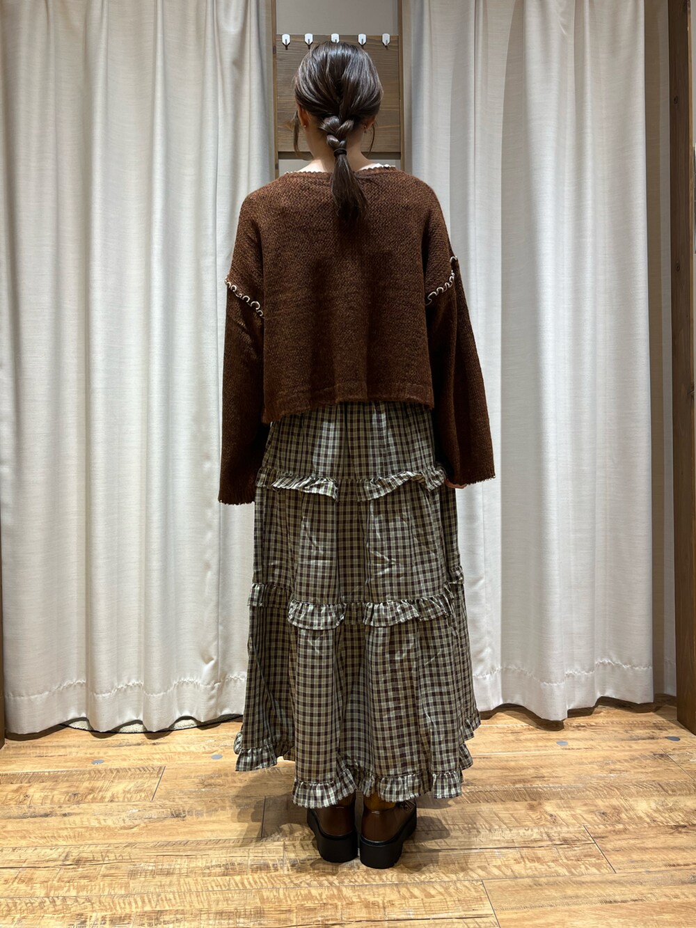 ブラウン系のカーディガン/ボレロ、ブラウン系のスカート、ブラウン系のその他シューズを着用したレディースの秋コーディネートの3枚目の写真