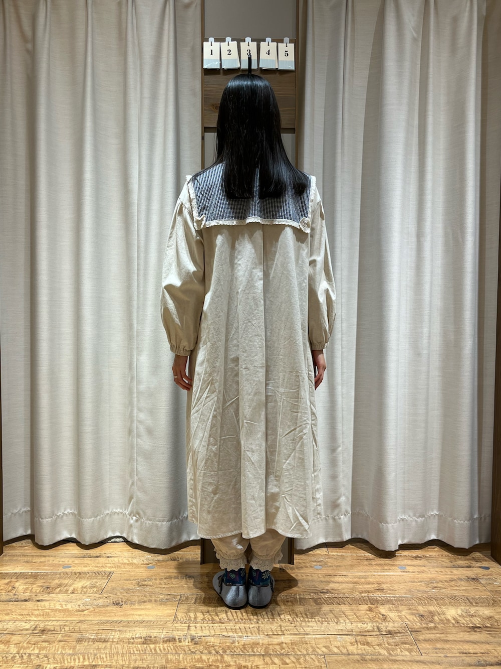 ベージュ系のワンピース、グレー系のドレスシューズ、ブルー系のシャツ/ブラウスを着用したレディースの冬コーディネートの3枚目の写真