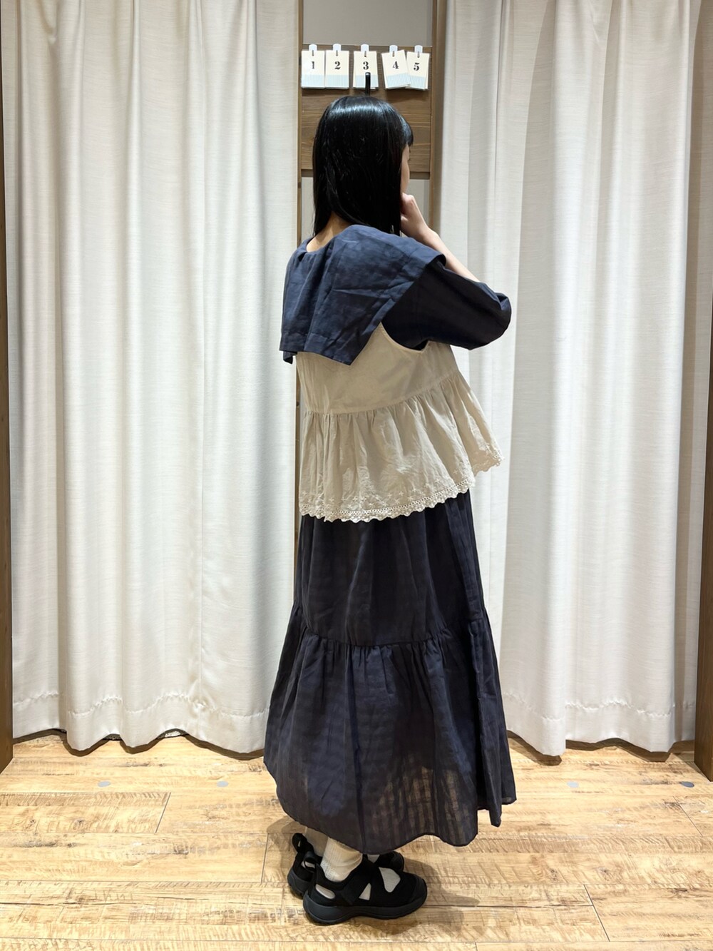 グレー系のワンピース、ホワイト系のベストを着用したレディースの夏コーディネートの2枚目の写真