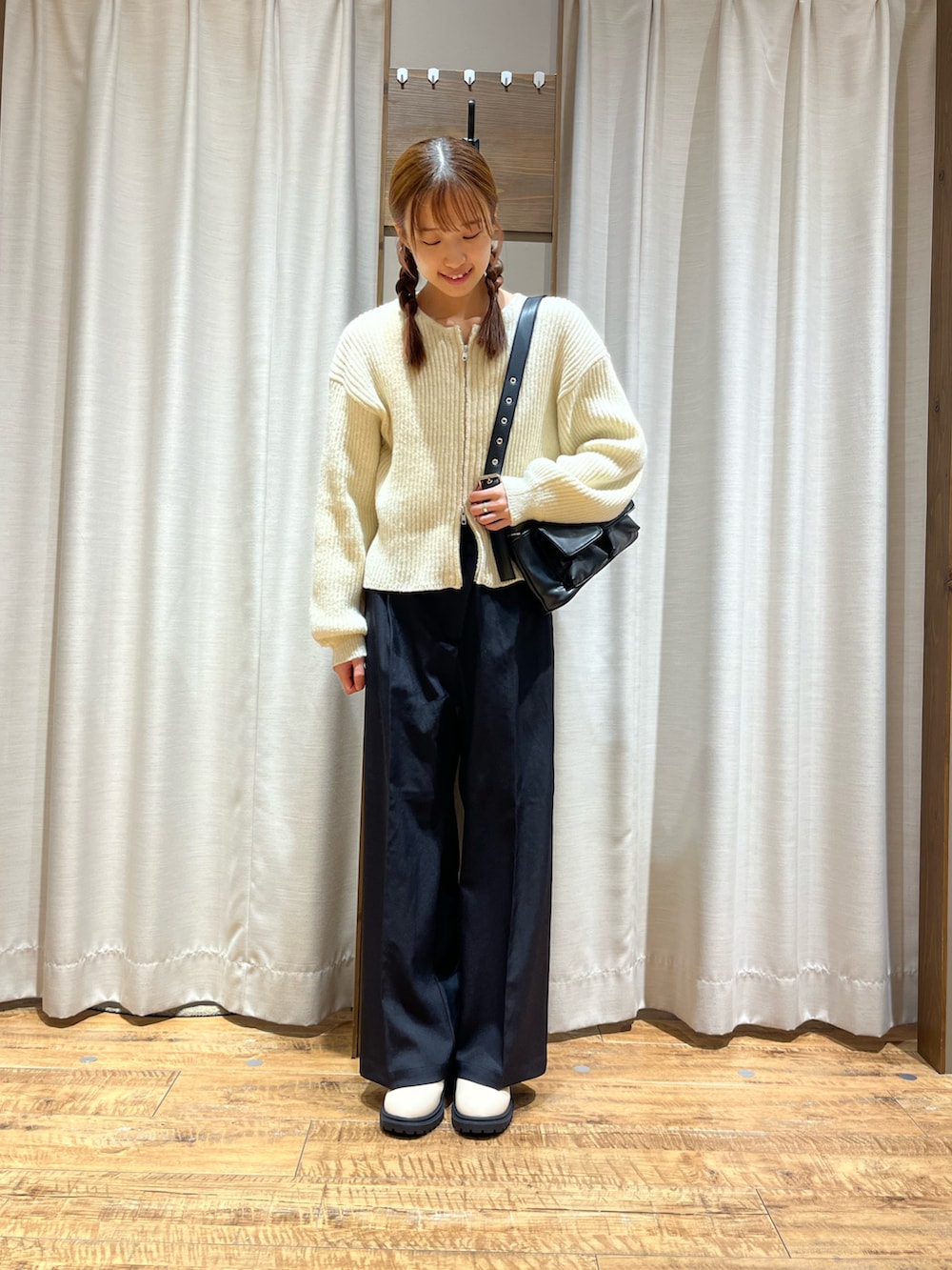 ブラック系のその他パンツ、ホワイト系のカーディガン/ボレロ、ホワイト系のブーツを着用したレディースの冬コーディネートの2枚目の写真