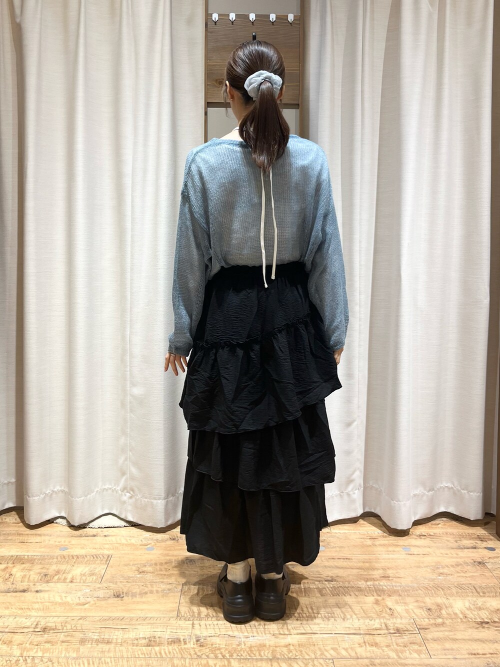 ホワイト系のスニーカー、グリーン系のスカート、ブルー系のニット/セーターを着用したレディースの秋コーディネートの2枚目の写真