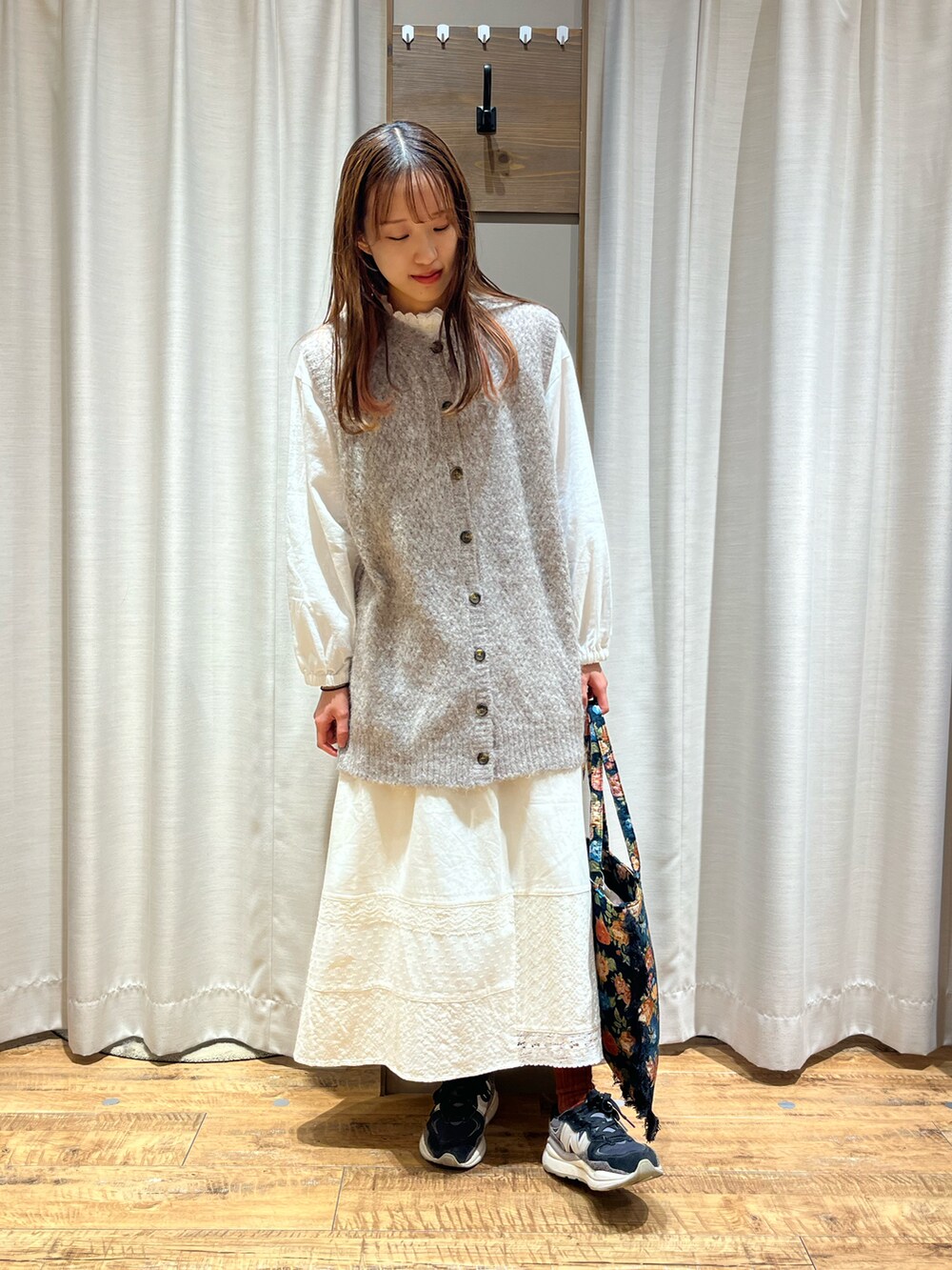 ベージュ系のベスト、ホワイト系のスカート、ブラック系のバッグを着用したレディースの冬コーディネートの3枚目の写真