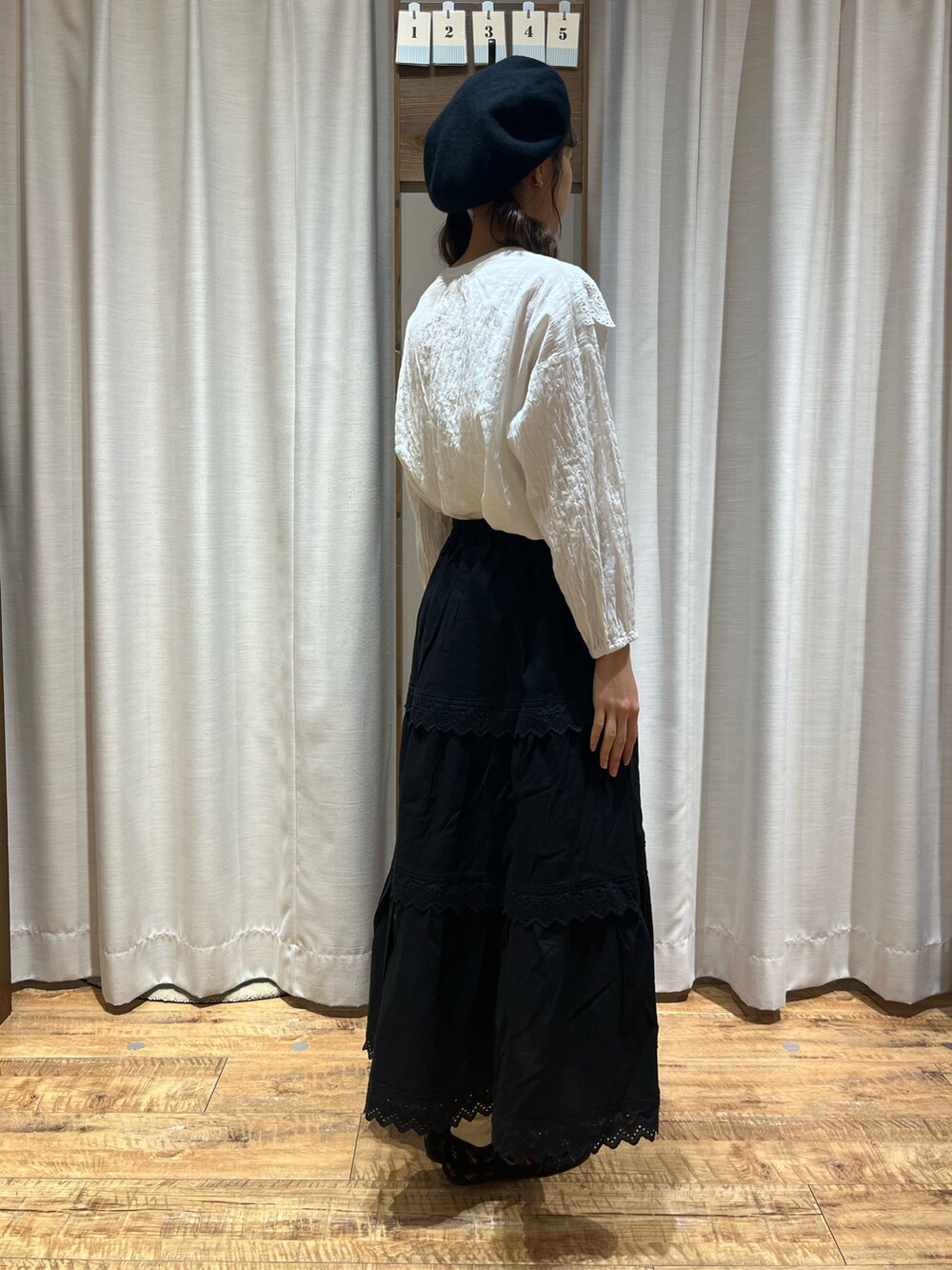 ブラック系のスカート、ブラック系のドレスシューズ、ホワイト系のシャツ/ブラウスを着用したレディースの秋コーディネートの2枚目の写真
