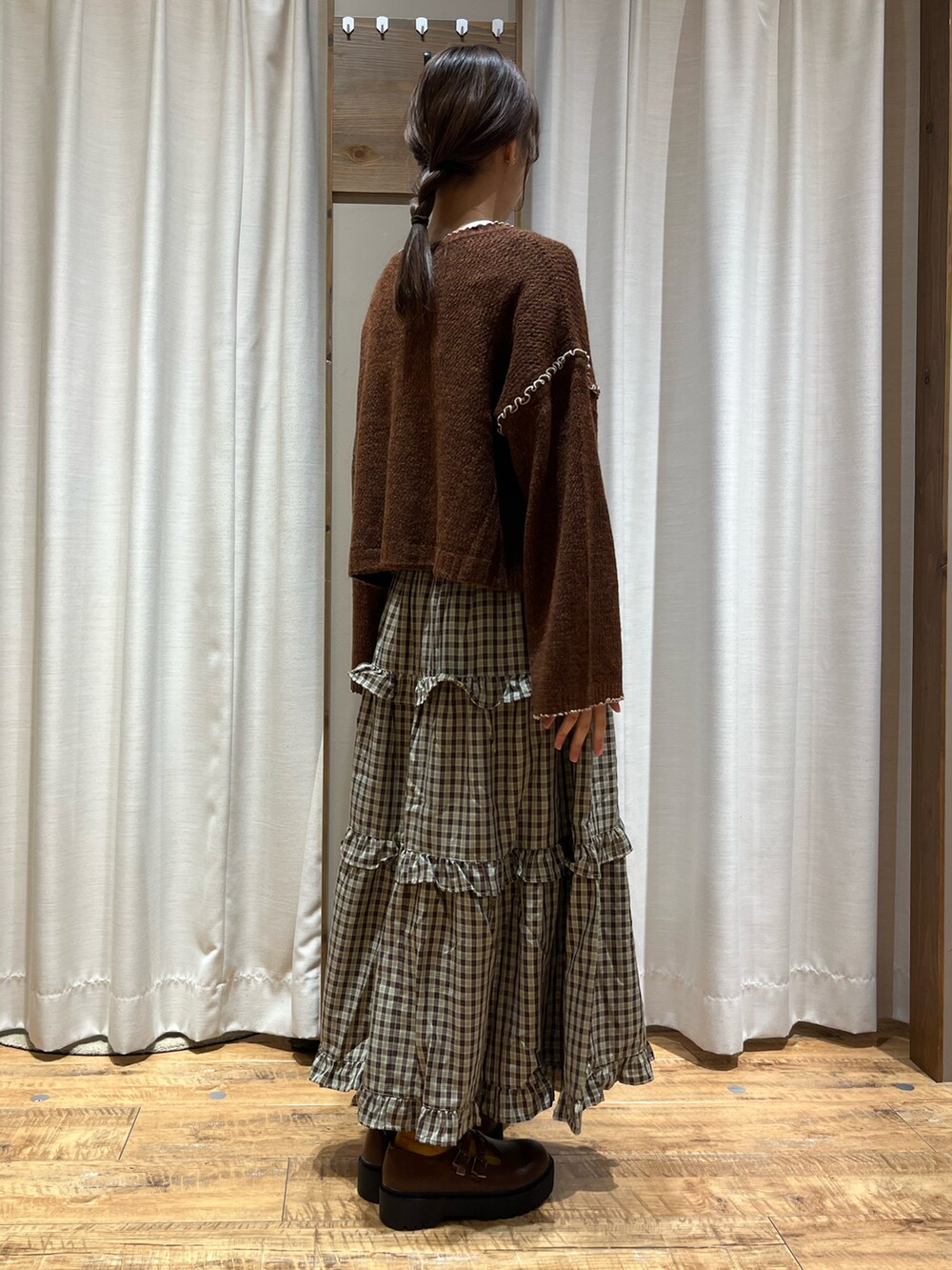 ブラウン系のカーディガン/ボレロ、ブラウン系のスカート、ブラウン系のその他シューズを着用したレディースの秋コーディネートの2枚目の写真