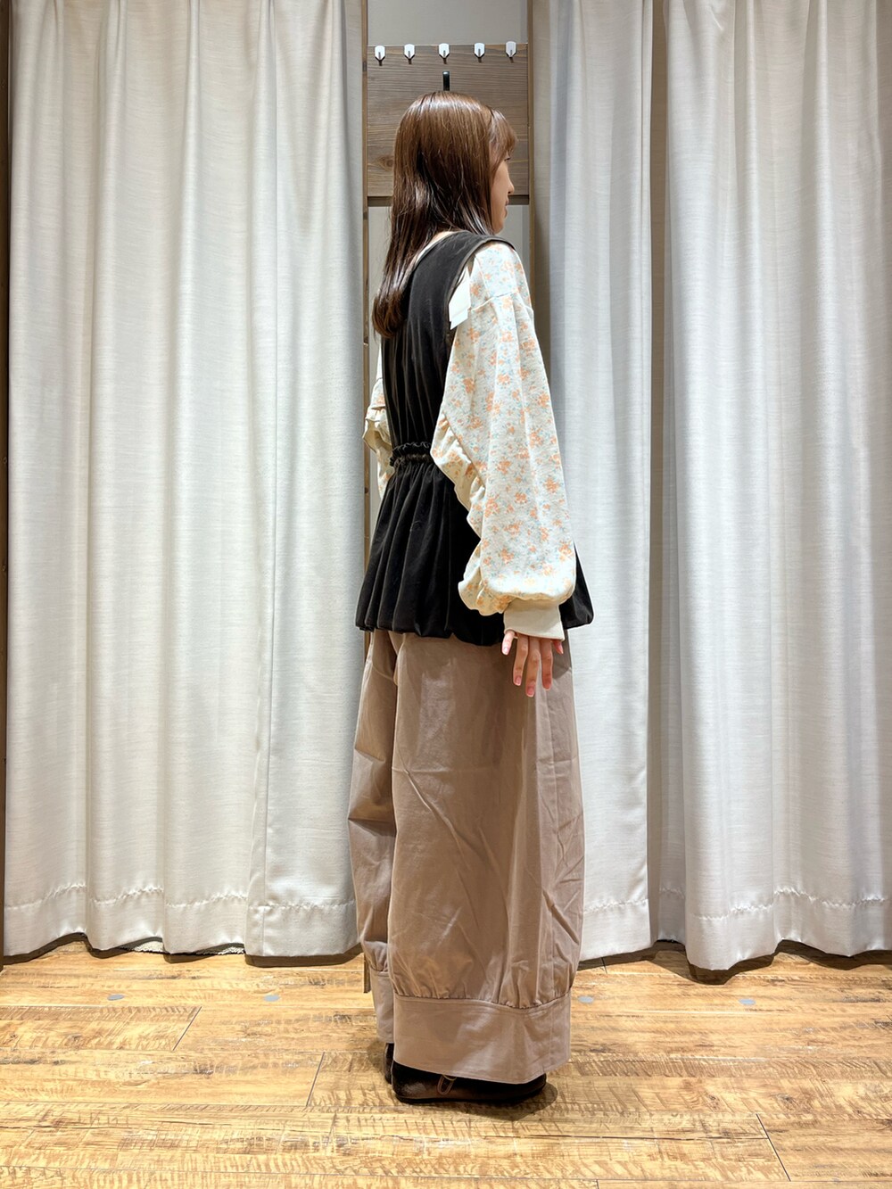 ベージュ系のパンツ、ブラウン系のベスト、イエロー系のトップスを着用したレディースの秋コーディネートの2枚目の写真