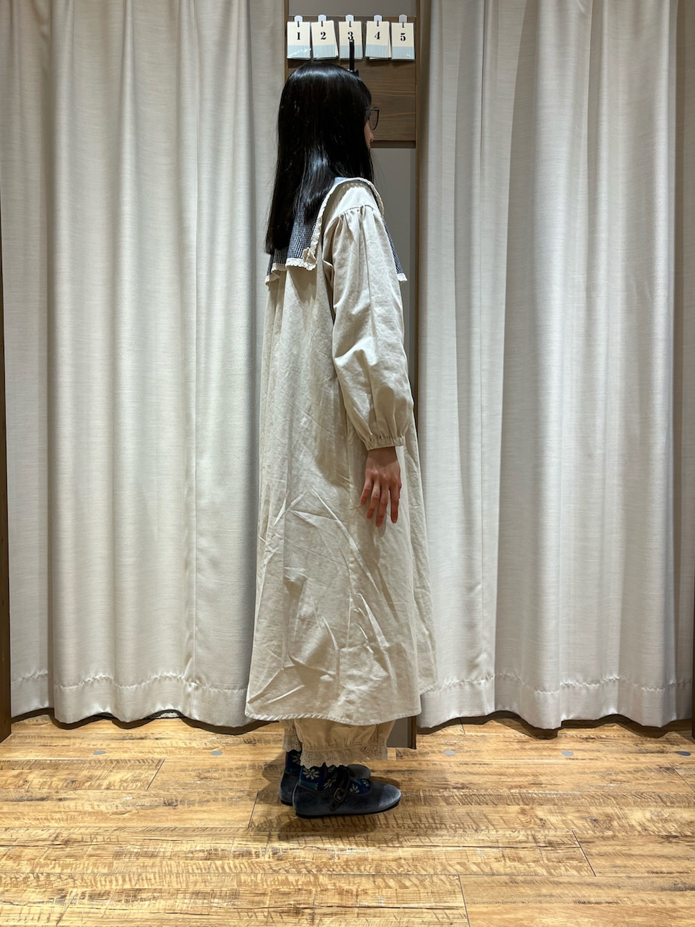 ベージュ系のワンピース、グレー系のドレスシューズ、ブルー系のシャツ/ブラウスを着用したレディースの冬コーディネートの2枚目の写真