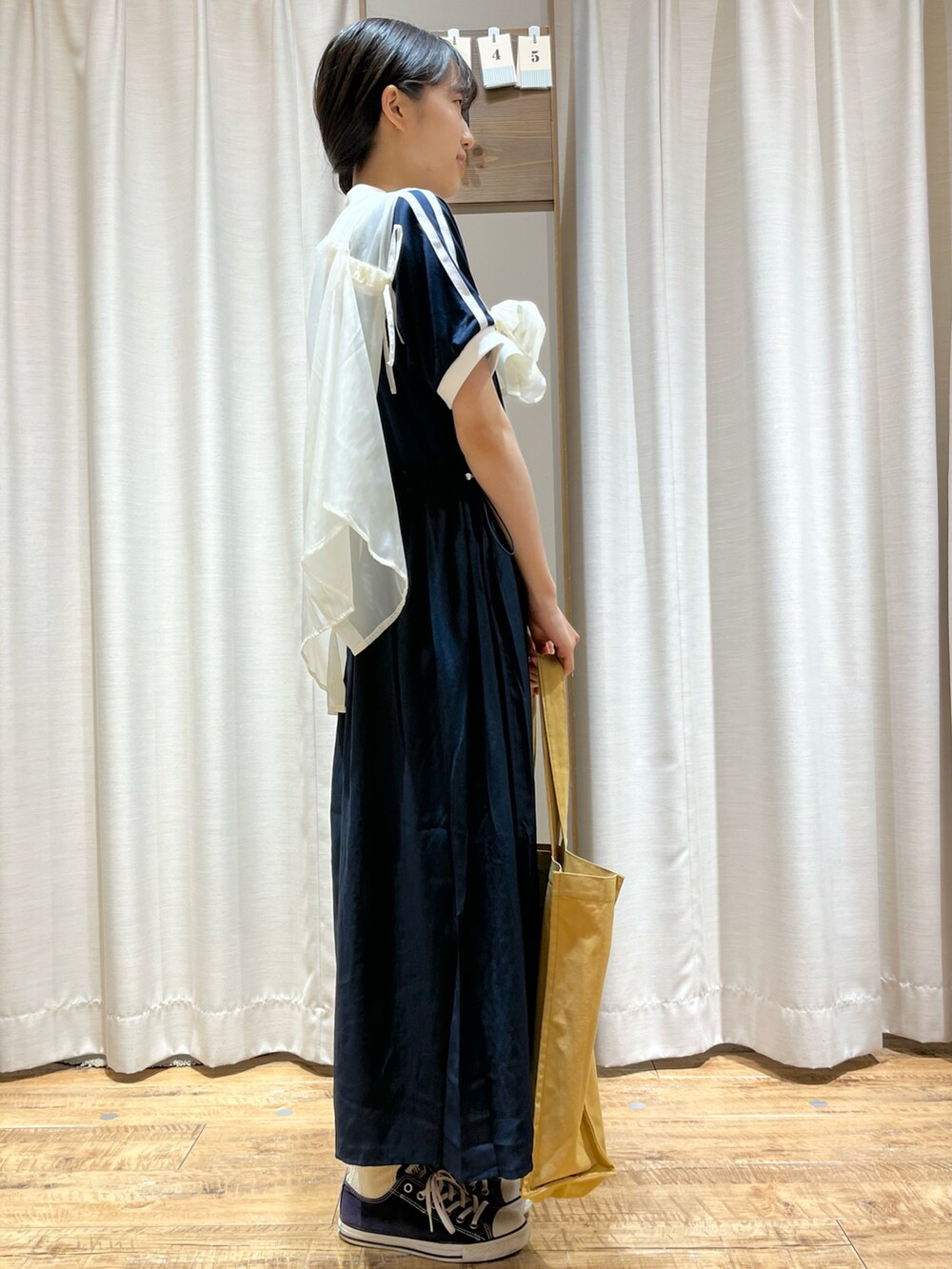 ブルー系のワンピース、ホワイト系のシャツ/ブラウス、イエロー系のハンドバッグを着用したレディースの夏コーディネートの2枚目の写真