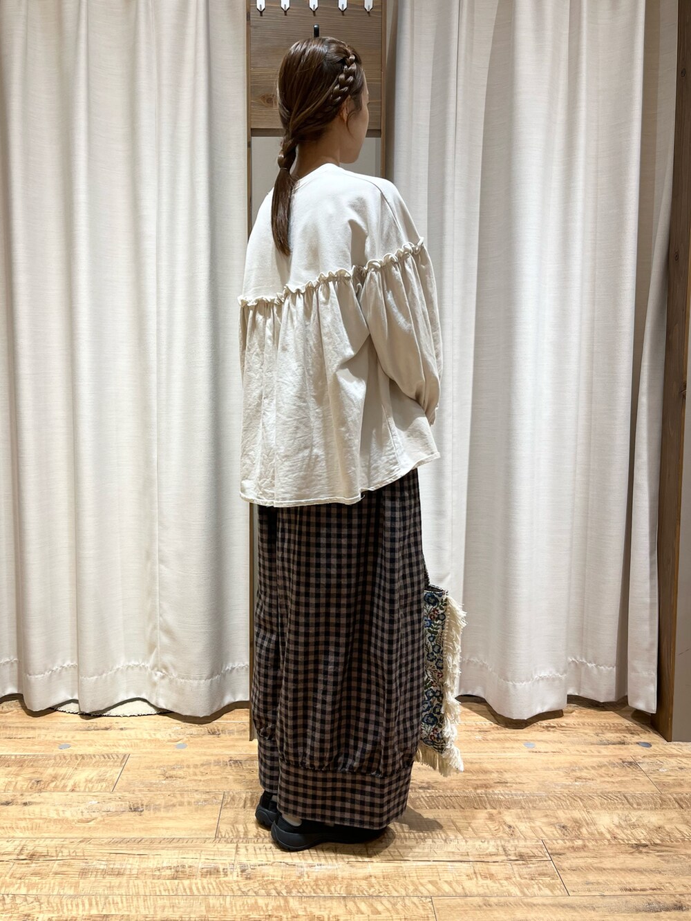 ホワイト系のトップス、ブラウン系のその他パンツ、ホワイト系のバッグを着用したレディースの秋コーディネートの2枚目の写真