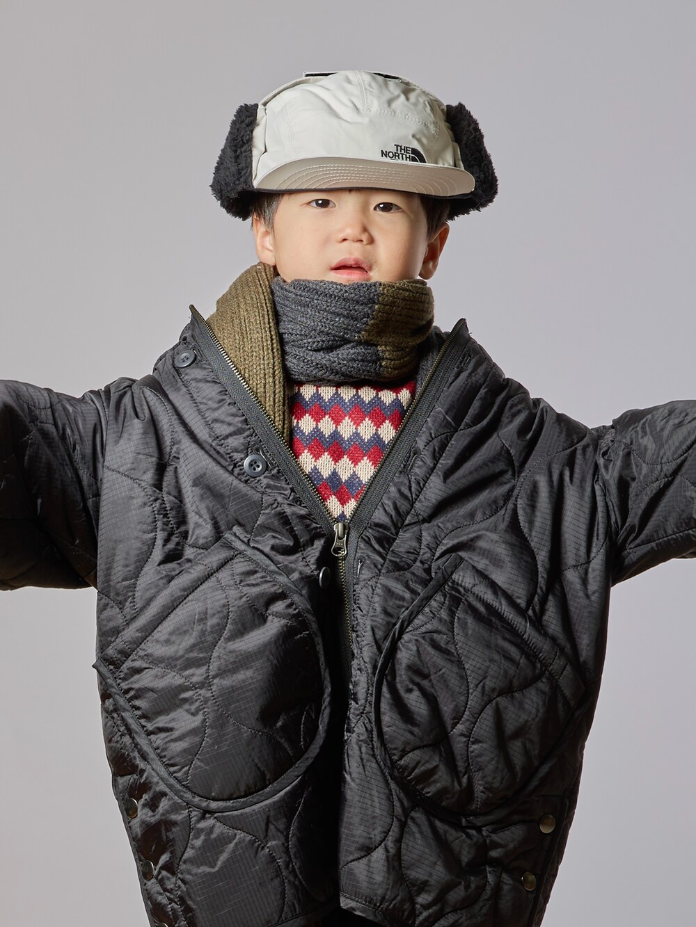 ブラック系のダウンジャケット/コート、ブルー系のスウェット、ブルー系のデニムパンツを着用したキッズの秋コーディネートの3枚目の写真