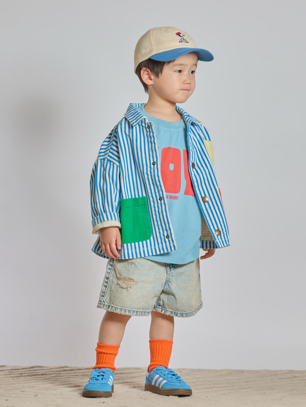 ブルー系のスニーカー、ブルー系のデニムパンツ、ブルー系のカバーオールを着用したキッズの春コーディネートの4枚目の写真