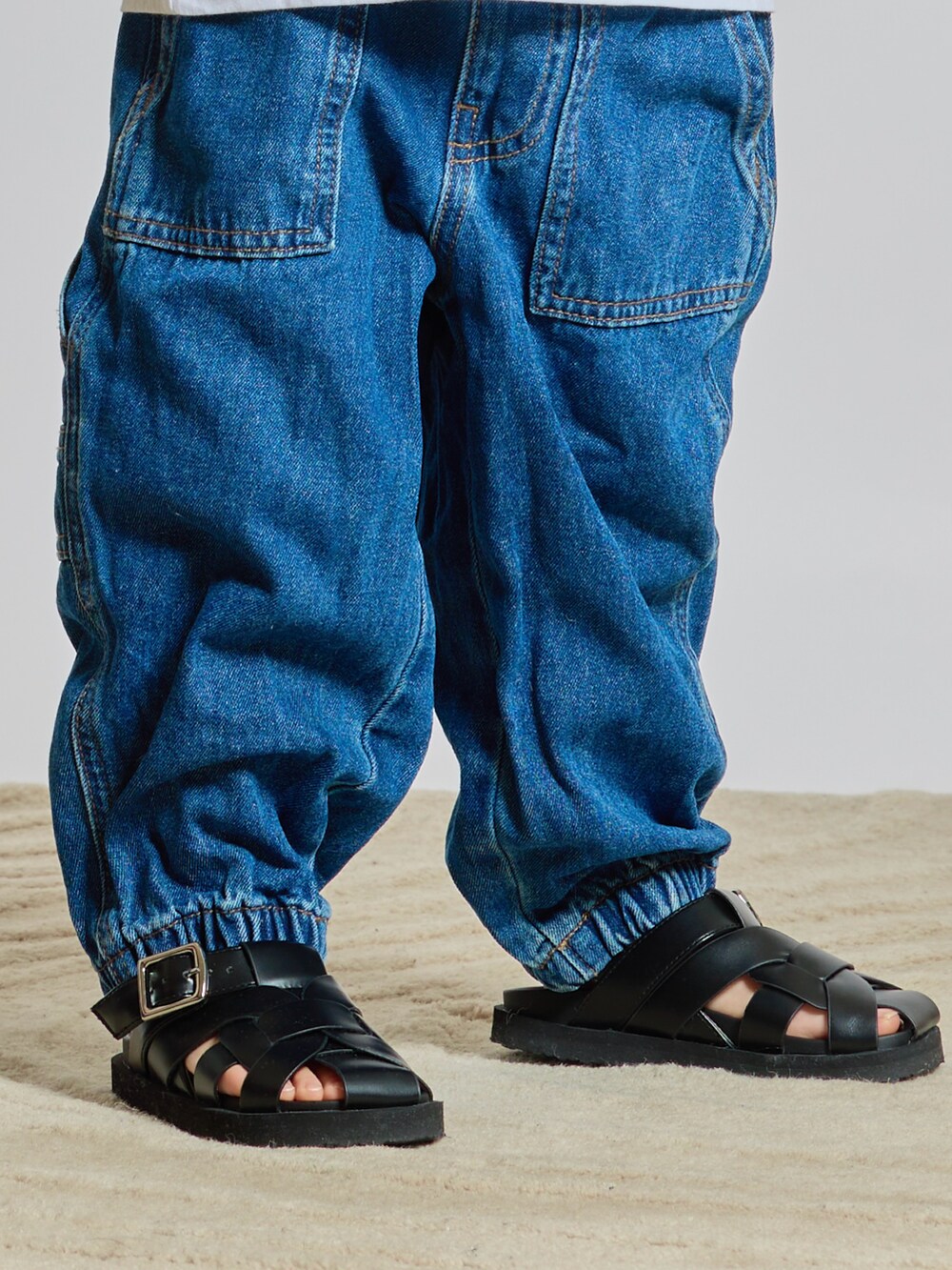 ブラック系のサンダル、ホワイト系のTシャツ/カットソー、ベージュ系のカーディガン/ボレロを着用したキッズの夏コーディネートの3枚目の写真