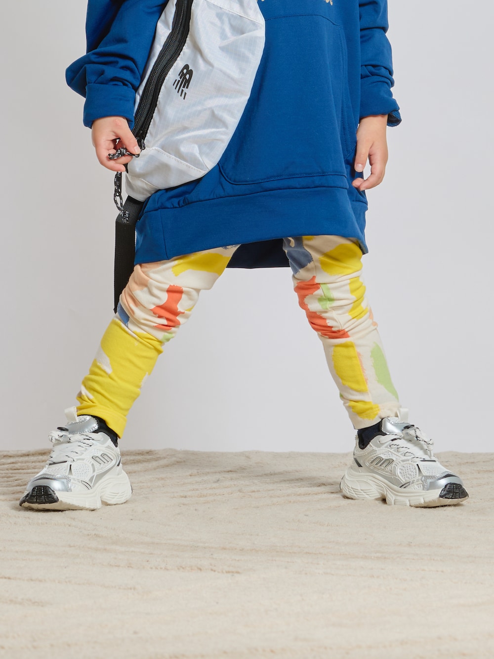 ブルー系のスウェット、ホワイト系のボディバッグ/ウエストポーチ、ホワイト系のスニーカーを着用したキッズの春コーディネートの3枚目の写真