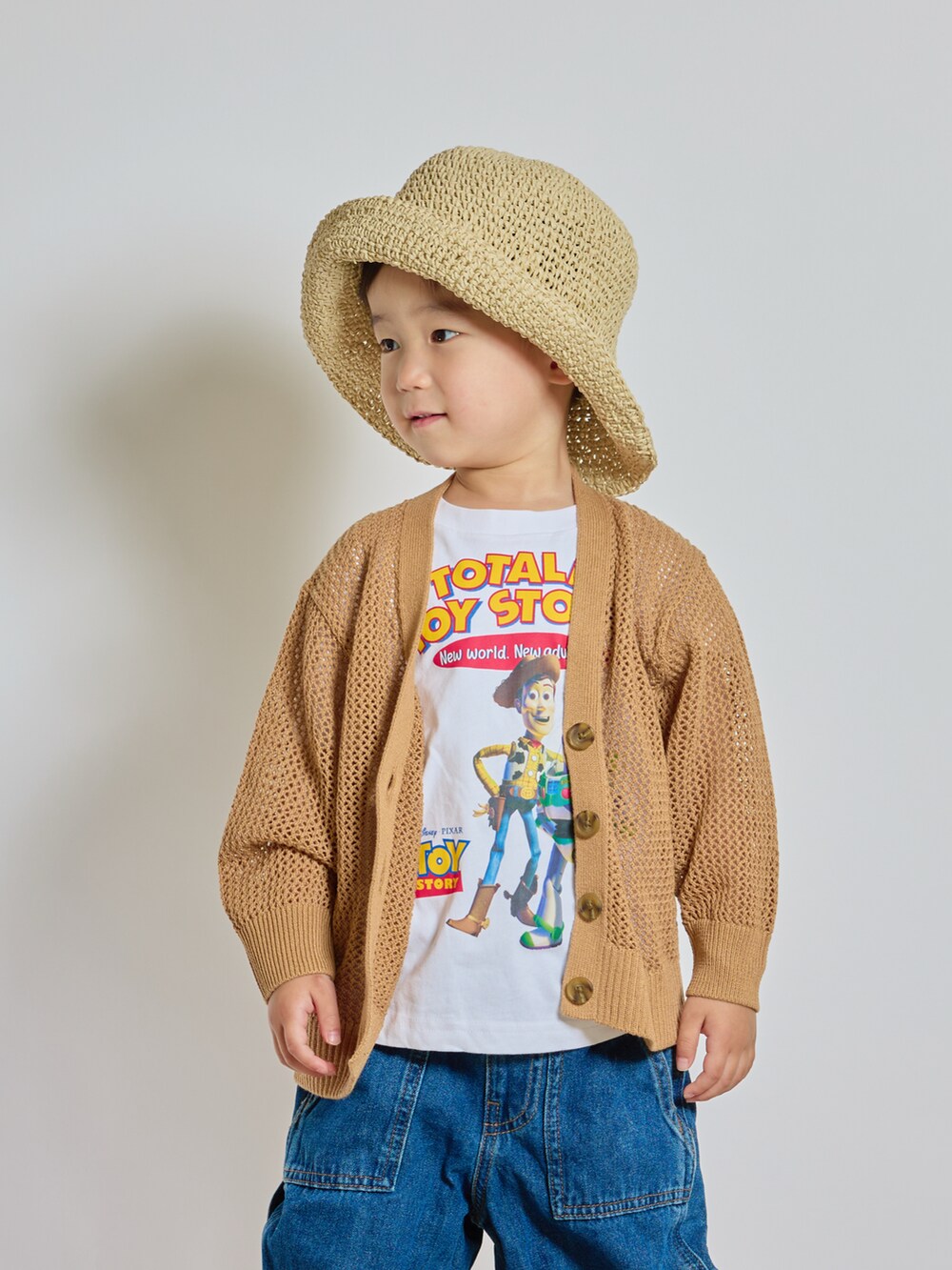 ブラック系のサンダル、ホワイト系のTシャツ/カットソー、ベージュ系のカーディガン/ボレロを着用したキッズの夏コーディネートの2枚目の写真