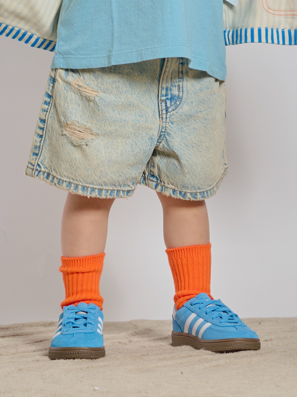 ブルー系のスニーカー、ブルー系のデニムパンツ、ブルー系のカバーオールを着用したキッズの春コーディネートの3枚目の写真