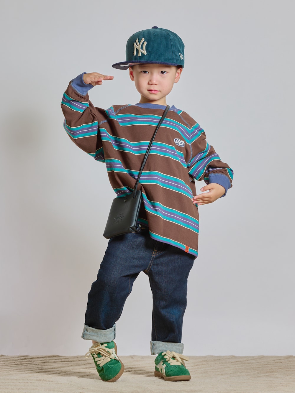 ブラウン系のTシャツ/カットソー、ブルー系のデニムパンツ、ブラック系のショルダーバッグを着用したキッズの秋コーディネートの2枚目の写真